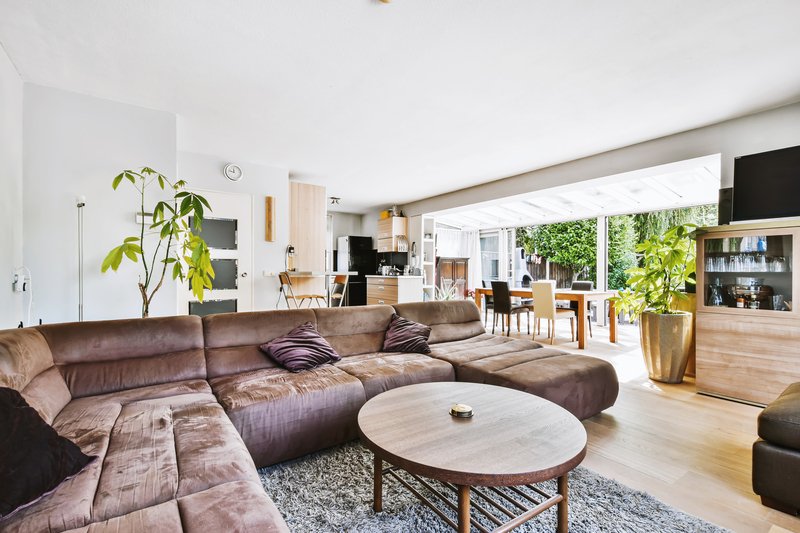 Sala cafe con mesa de centro redonda y ventanales amplios de fondo